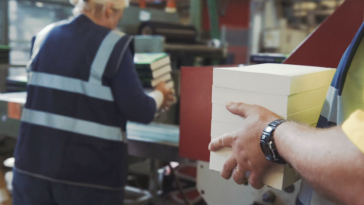 Person carrying books in distribution centre